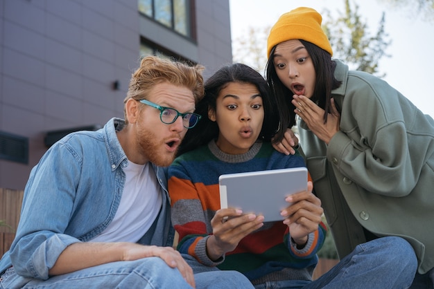 multiraciale vrienden met behulp van digitale tablet kijken naar video