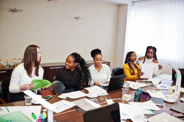 Multiraciale vrouwelijke collega's, bemanning van divercity vrouwelijke partners in het kantoor zitten aan de tafel.