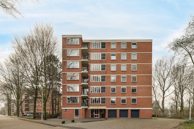 A multistorey brick building standing apart from all the others surrounded by trees