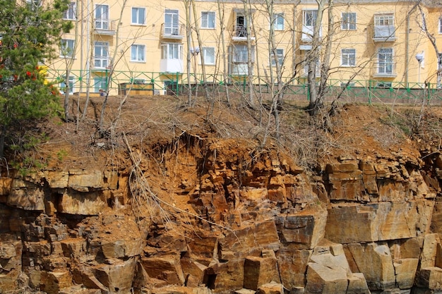 Foto un edificio a più piani in piedi su una scogliera di una costa rocciosa