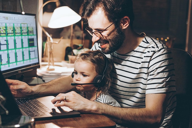 Multitasking freelance and fatherhood concept working father with a baby daughter and laptop