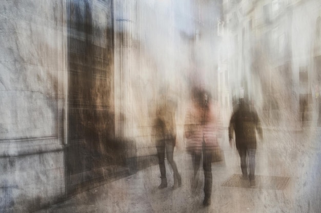 A multitude of people in motion walking briskly down a bustling city street their figures blending into a vibrant blur of activity and energy