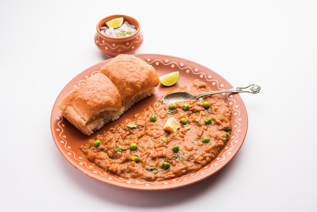 Mumbai Style Pav bhaji is een fastfood gerecht uit India, bestaat uit een dikke groentecurry geserveerd met een zacht broodje, geserveerd in een bord