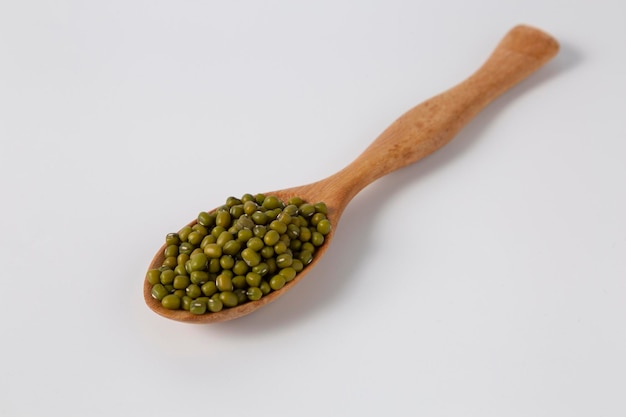 Mung bean in wood spoon on white background studio shot