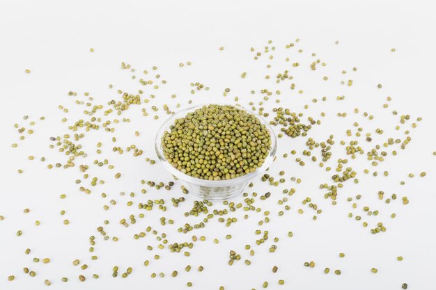 Mung beans scatter around a bowl of glass