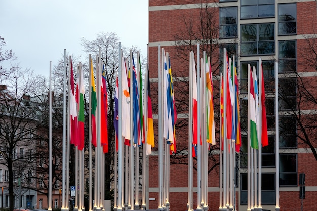 Monaco / germania - gennaio 2020: bandiere nazionali di diversi stati sui pennoni vicino all'ufficio europeo dei brevetti a monaco