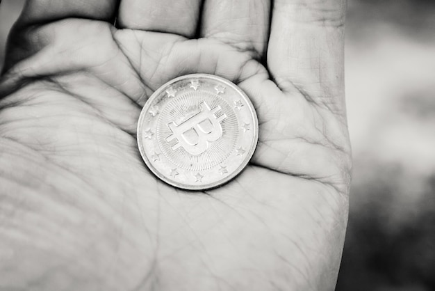 Munt bitcoin in de palm zwart-wit close-up weergave