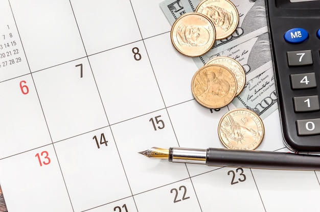 Munten dollars met rekenmachine op de kalender