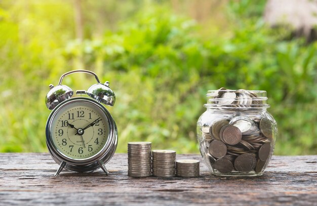 Munten in pot met geld stap stap groeiende geld en wekker