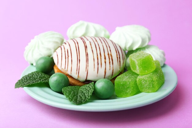 Muntkleurschuimgebakjes, muntsuikergoed en smakelijke cake op kleurenachtergrond