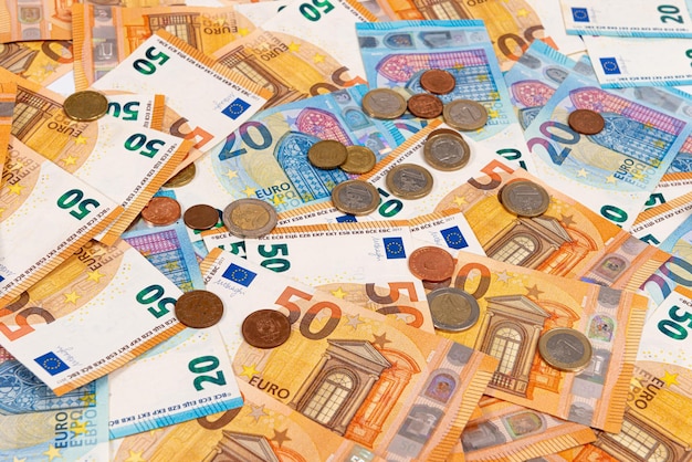 Foto muntstukken op de achtergrond van eurobankbiljetten euro-biljetten als onderdeel van het economische en handelssysteem