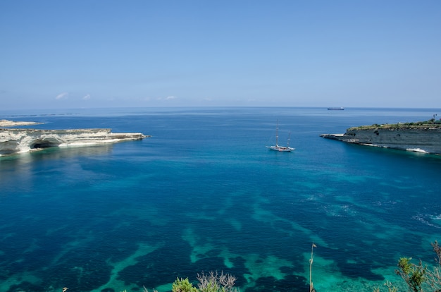 Munxar pad in de buurt van Marsaskala, Malta. Witte rotsen met blauw water in Malta dichtbij Marsaxlokk, Heilige Peter Pool.