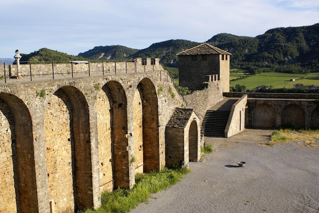 Muralla del Castillo de Ainsa. Muro de fortificación medieval con torre con arcos y piedra