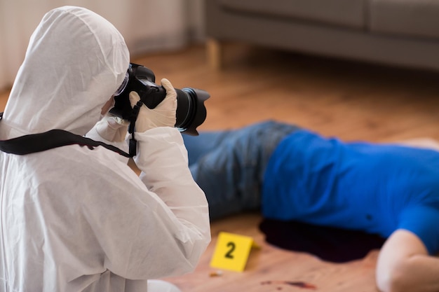 Foto indagine sull'omicidio esame forense e concetto di persone criminalista con telecamera fotografando il corpo della vittima maschile morta sulla scena del crimine