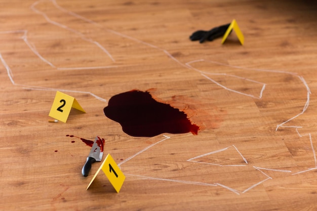 murder kill and forensic evidence concept chalk outline of body and knife in blood lying on floor at crime scene