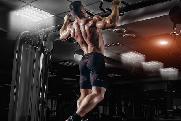 Photo muscle athlete man in gym making elevations bodybuilder training in gym