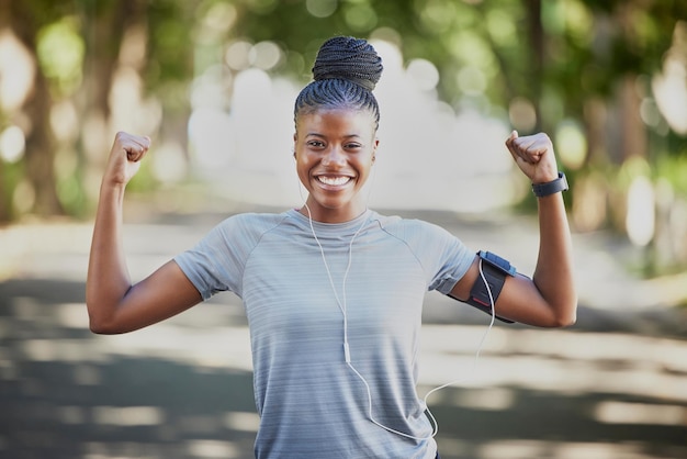 Muscle flex fitness en portret van zwarte vrouw in park show biceps voor trainingsdoel wellness en training Sportgezondheid motivatie en blij meisje voor cardiotraining hardlopen en sterk lichaam