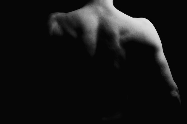 Muscle necj and back of man showing muscle low key black and\
white photo male model athlete with muscular sexy body and bare\
back