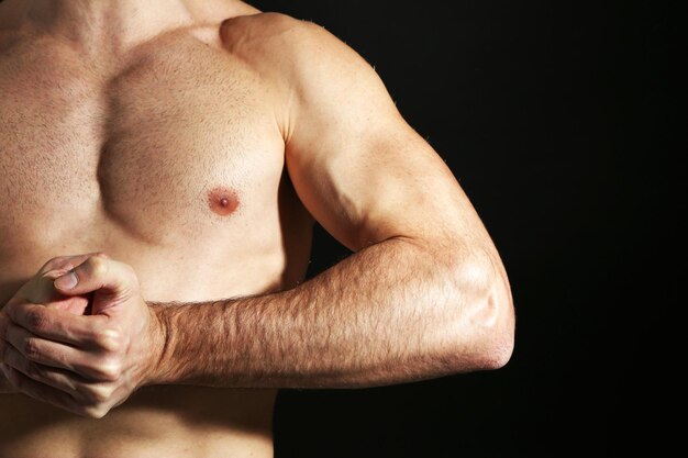 Muscle young man on black background