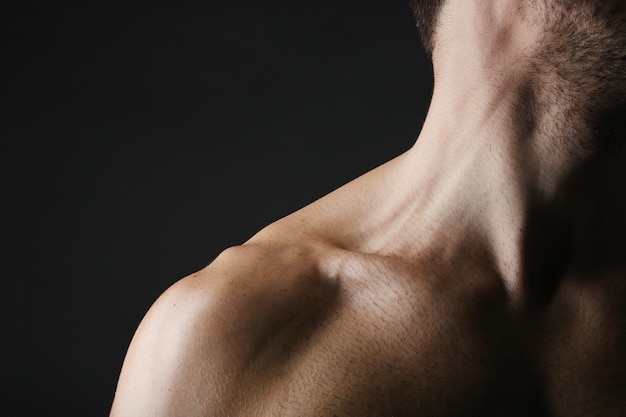 muscle young man on dark background