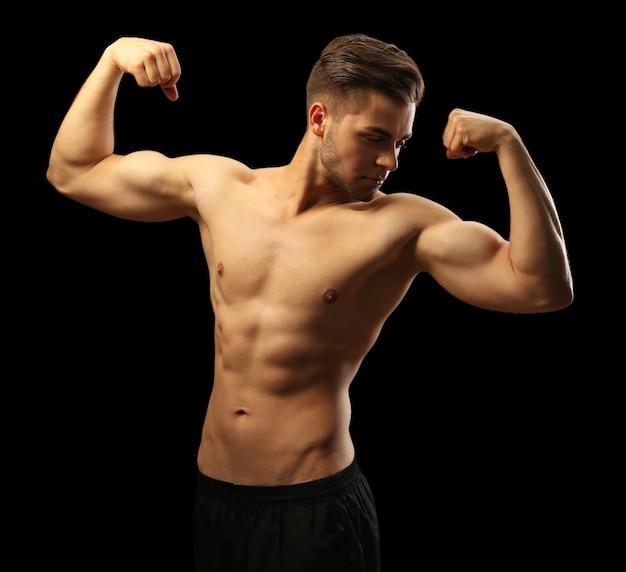Muscle young man on dark surface