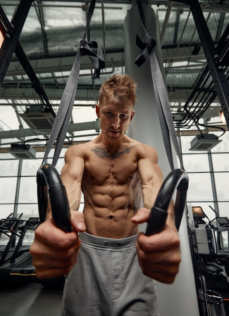 Muscleup 운동 젊은 남자는 체조 링에 체육관에서 강렬한 크로스 핏 운동을 하고 있습니다