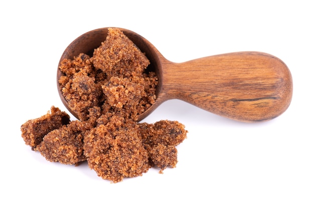 Muscovado sugar in wooden spoon isolated on white background barbados sugar khandsari or khand