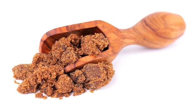 Muscovado suiker in houten lepel geïsoleerd op witte achtergrond barbados suiker khandsari of khand