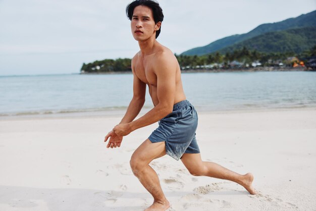 Photo muscular asian athlete running on the beach fueling fitness in lifestyle