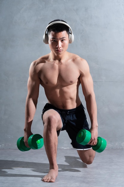 Muscular Asian man posing on gray background