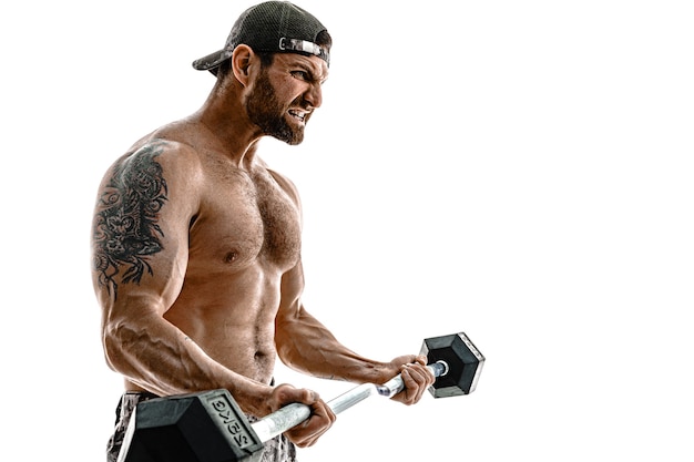 Photo muscular athlete bodybuilder man in camouflage pants with a naked torso workout with dumbbell on a white wall. isolate