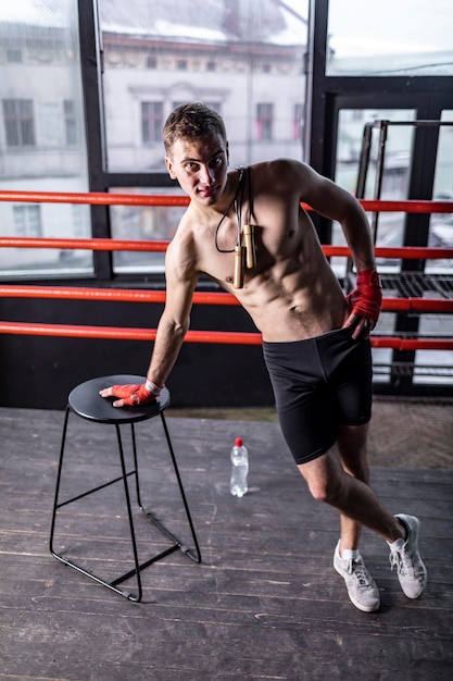 Muscular athlete man with rope in the ring