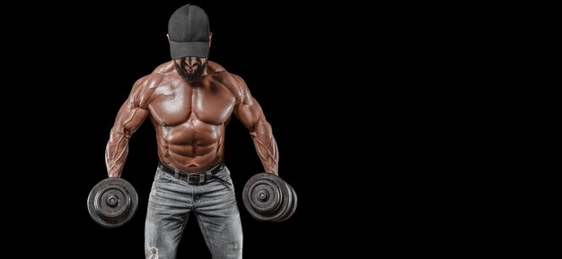 Muscular athlete posing with dumbbells. Fitness and classic bodybuilding concept.