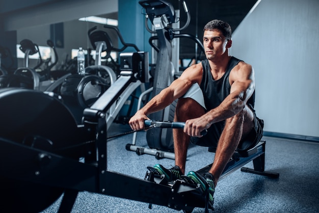 Muscular athlete training press on exercise machine.