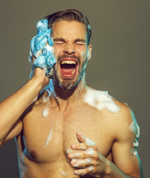 Muscular attractive bearded man taking shower portrait of handsome sexy man with naked upper body