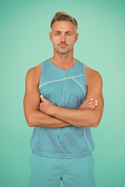 Muscular body Man well groomed athlete on blue background Mature but still in good shape Exercising in gym for better health Healthy lifestyle Gym wear and sports fashion for men Guy in gym