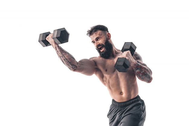 Muscular bodybuilder guy doing exercises with dumbbells