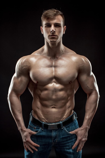 Muscular bodybuilder guy doing posing over black background