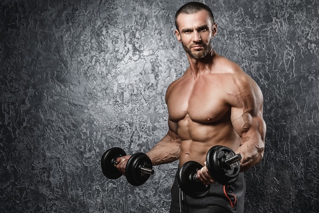 Muscular bodybuilder working out with a dumbbells