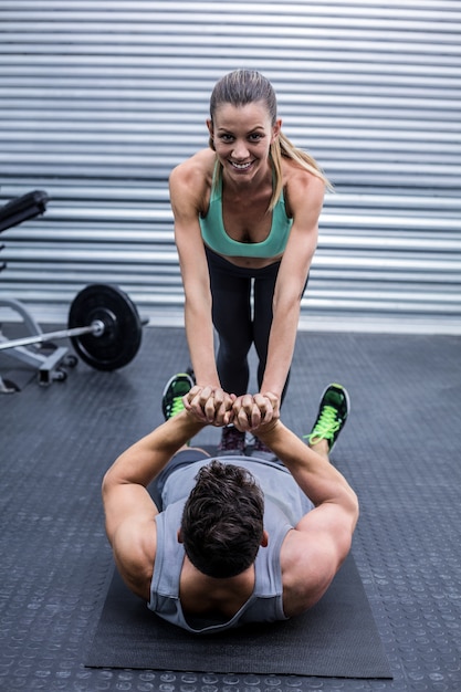 Muscular couple doing core exercises