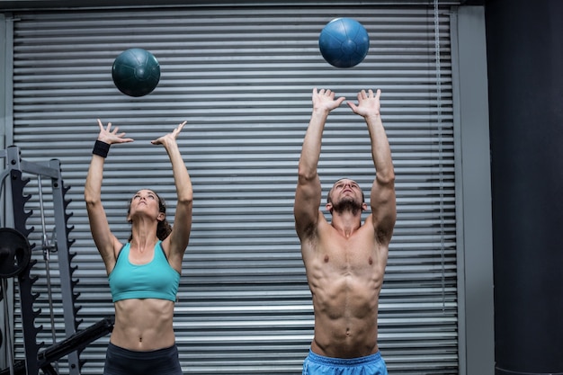 Muscular couple throwing ball in the air