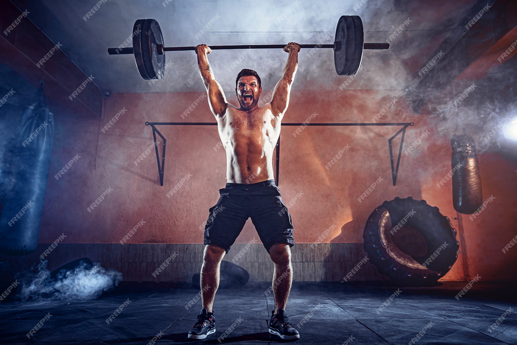 Premium Photo | Muscular fitness man doing deadlift a barbell over his head in modern fitness center. functional training. snatch exercise. smoke on wall.