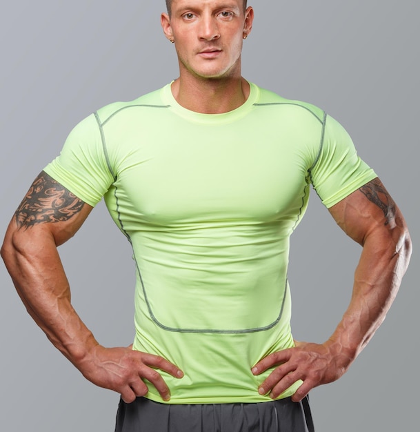 Photo muscular guj in green sportswear. isolated on grey