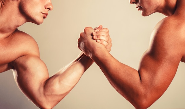 Muscular hand. Clasped arm wrestling. Two men arm wrestling. Rivalry, closeup of male arm wrestling. Two hands. Hand wrestling, compete. Hands or arms of man.