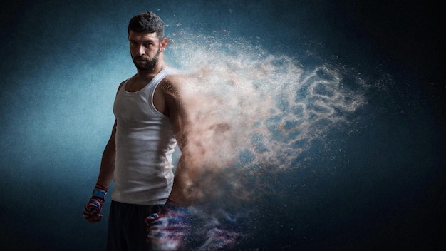 Muscular male boxer standing over dark background particles effect