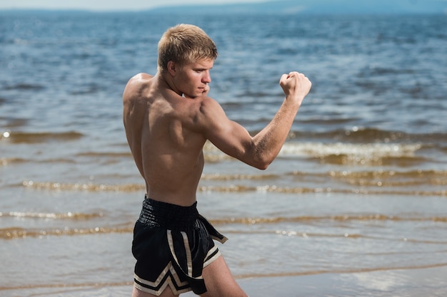 Muscular male fighter training. boxer trains in the open air