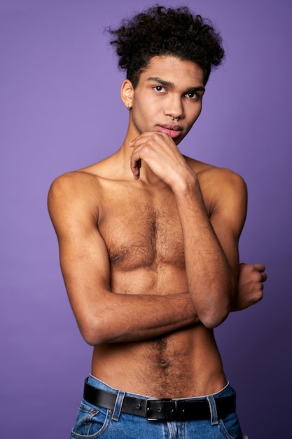 Muscular male stand on isolated background transgender model posing to camera american young man