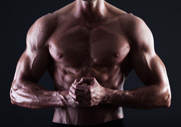 근육의 세부 사항을 보여주는 조명이 있는 근육질의 남성 몸통