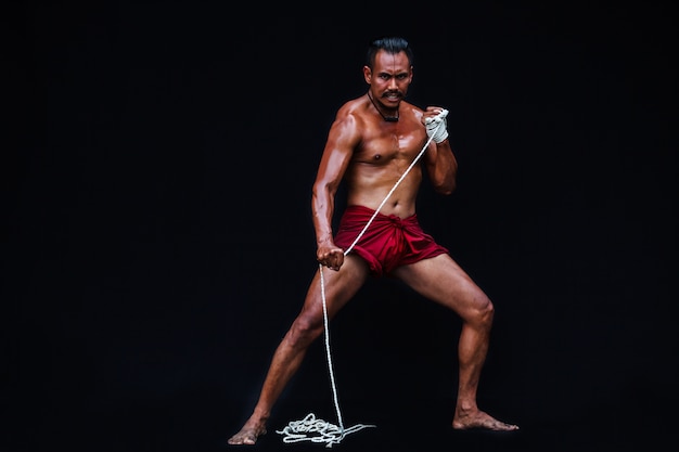 Muscular Man display Asian traditional Thai Boxing