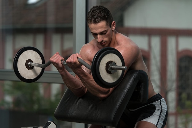 Muscular Man Doing Heavy Weight Exercise For Biceps